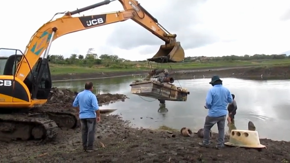 Maquinário removendo equipamento de dentro do açúde.