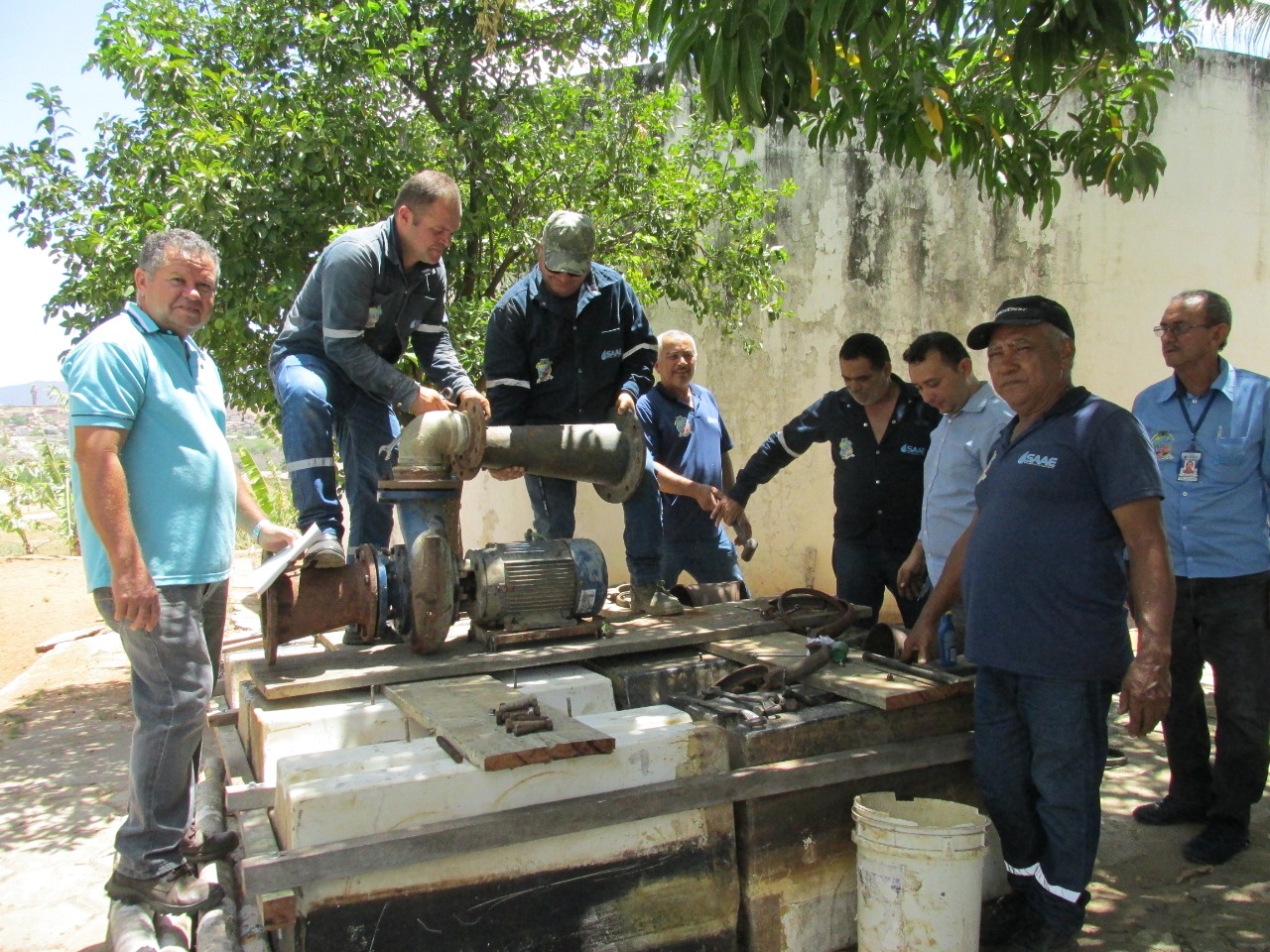 Equipe do SAAE de Canindé trabalhando em um motor.