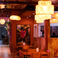 Bar do Zé. Espaço com mesas e cadeiras de madeiras, decorado com luzes pendentes