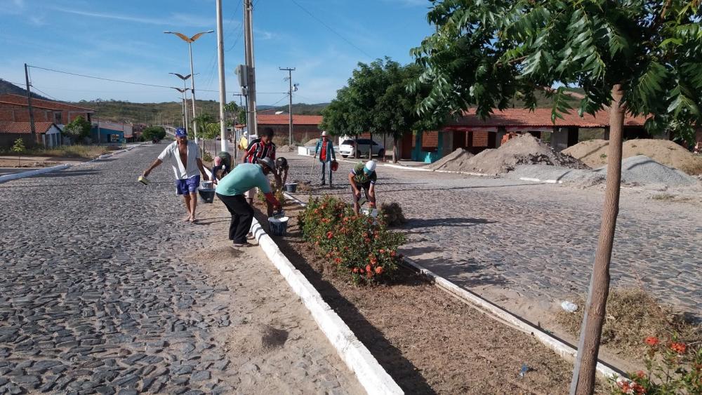 Homens pintando os meio-fios de uma rua
