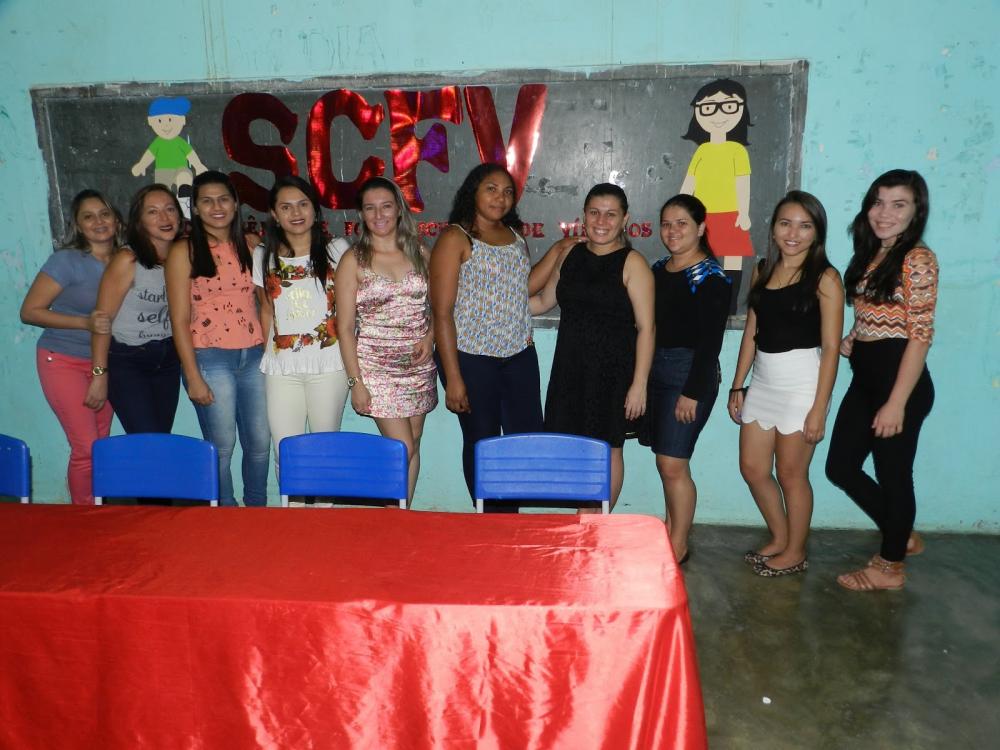 v&aacute;rias pessoas em p&eacute; posando para foto.