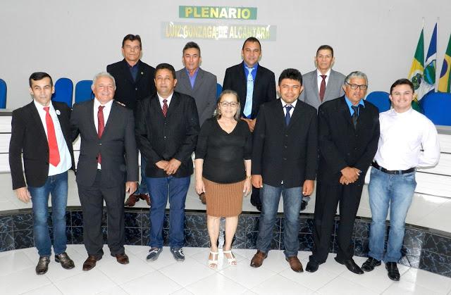 v&aacute;rias pessoas em p&eacute; posando para foto.