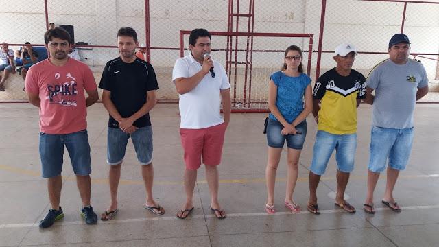 Prefeito Taiano falando ao microfone ao lado de outras pessoas que tamb&eacute;m est&atilde;o de p&eacute;