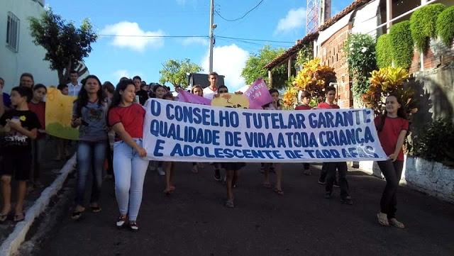 v&aacute;rios jovens com faixa em caminhada contra a explora&ccedil;&atilde;o de crian&ccedil;as e adolescentes.