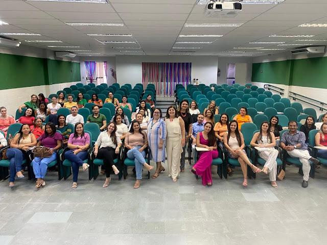 Foto de varias pessoas sentadas em uma sala de palestra.