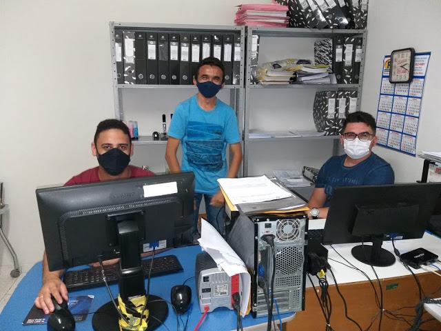 Foto de três homens mexendo no computador