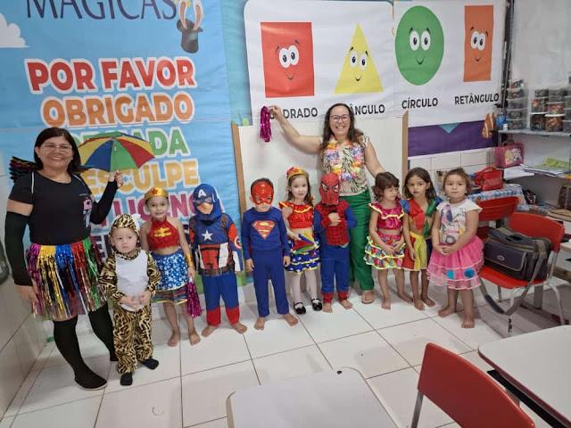 Foto de duas professoas e algumas crianças fantaseadas para o Carnaval da Escola.