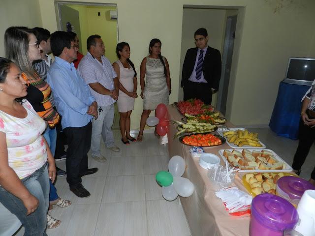 V&aacute;rias pessoas de p&eacute; enfrente uma mesa de caf&eacute; da manh&atilde; com bolos frutas, sucos etc.