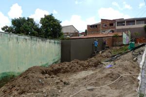 Imagem de um trator pr&oacute;ximo a um muro.